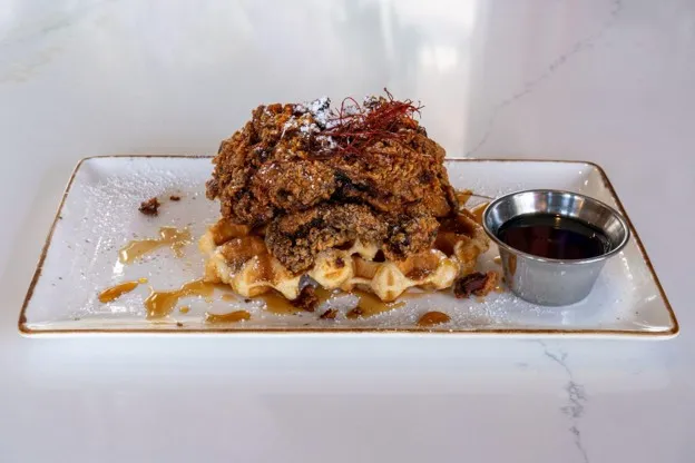 The New Chick On The Block: crispy fried chicken over a sugar-studded waffle with hot honey and syrup
