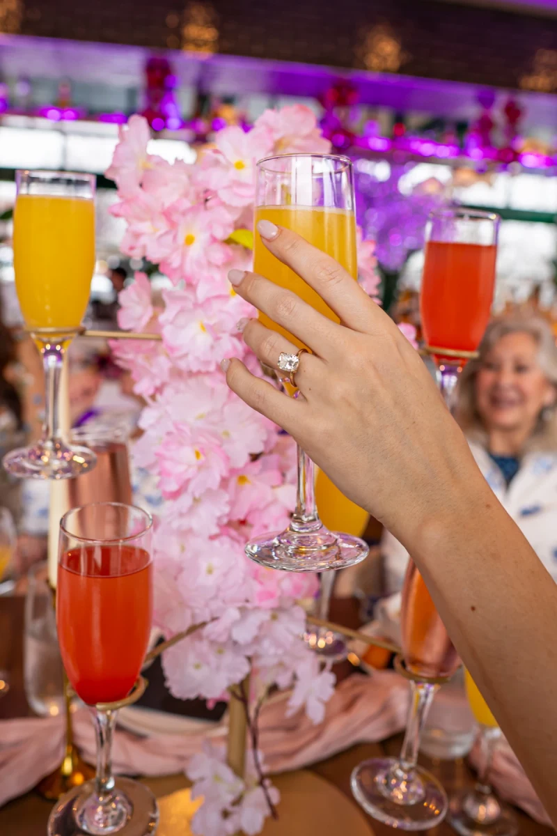 A guest raising a mimosa among cherry blossoms at Bloom Room